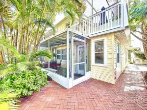 a house with glass doors and a patio at Seaclusion Updated condo steps to beach & bay in Bradenton Beach