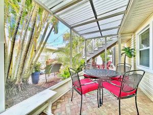 a patio with a table and chairs on a porch at Seaclusion Updated condo steps to beach & bay in Bradenton Beach
