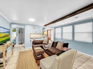 a living room with a couch and a tv at Seaclusion Updated condo steps to beach & bay in Bradenton Beach