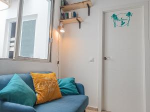 a blue couch in a living room with a window at Daydream Medano Coliving in El Médano