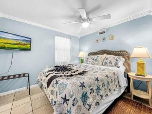 a bedroom with a bed and a ceiling fan at Seaclusion Updated condo steps to beach & bay in Bradenton Beach