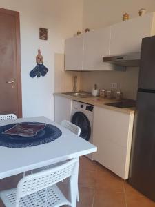 uma cozinha com uma mesa, um fogão e uma máquina de lavar louça em La casetta all'attico em Palermo