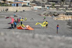a group of people on a beach with kites at Daydream Medano Coliving in El Médano