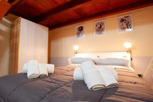una camera da letto con un grande letto con asciugamani di Casa Pistò in Dante Square a Napoli