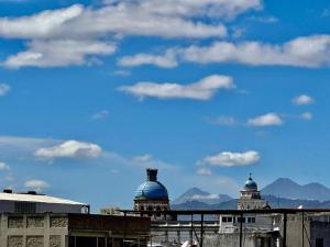dos cúpulas de edificios con montañas en el fondo en Hostal Amaya, en Guatemala