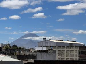 una montaña en la distancia con un edificio en primer plano en Hostal Amaya, en Guatemala