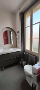 a bathroom with a sink and a toilet and a mirror at Hôtel Restaurant Le Moulin de la Renne Adults Only proche Zoo de Beauval in Thésée +82 photos