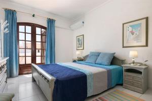 a bedroom with a blue bed and a window at Roulito's House in Altura
