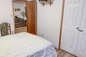 1 dormitorio con cama blanca y espejo en One Acre Wood, en Eagle River