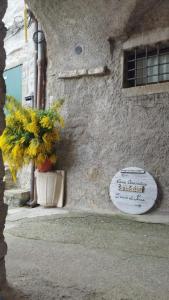 um sinal na lateral de um edifício com uma planta em l'arco di Sersa em Riccò del Golfo di Spezia