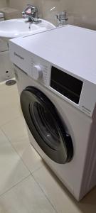 a washing machine in a bathroom next to a sink at Apartamento T1 Mobilado Espargos/Sal in Espargos