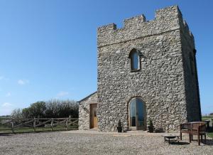 a stone building with a bench in front of it at Kinley Tower 