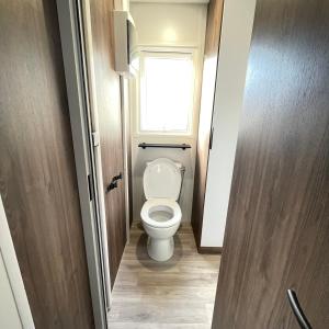 a small bathroom with a toilet with a window at Mobilhome neuf La Dolce Vita in Claouey