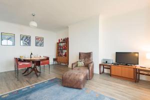 a living room with a television and a table with a chair at Sea View Apartment in Folkestone