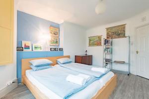 a bedroom with a large bed with blue and white sheets at Sea View Apartment in Folkestone