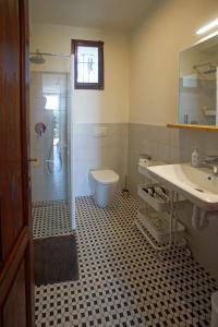 La salle de bains est pourvue de toilettes, d'un lavabo et d'une douche. dans l'établissement App 1 per famiglie con splendida vista lago, à Belgirate