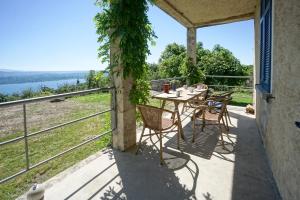 a patio with a table and chairs on a balcony at App 1 per famiglie con splendida vista lago in Belgirate