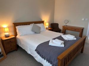 a bedroom with a large bed with two towels on it at South Downs Rural Retreats in Worthing