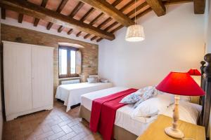 una camera con 2 letti e una lampada rossa di BorgoCuore a Todi