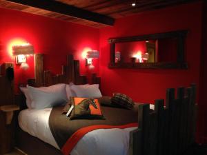 um quarto vermelho com 2 camas e um espelho em le A by neige et roc em Morzine