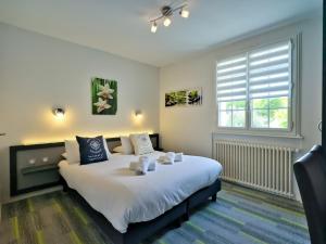 - une chambre avec un grand lit blanc et une fenêtre dans l'établissement Logis Le Prieuré, à Locronan