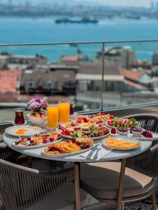 una mesa con platos de comida y bebidas. en Meroddi Barnathan Hotel, en Estambul