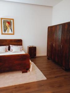 1 dormitorio con 1 cama y un gran armario de madera en B&b Nicole, en Valguarnera Caropepe