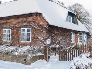 een stenen huis met een met sneeuw bedekt dak bij Holiday home Scheersbergkate in Steinbergkirche