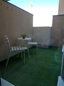 a patio with a table and chairs on a balcony at Apartamento Servet, parking gratuito, a 5 minutos de Sevilla in Bormujos