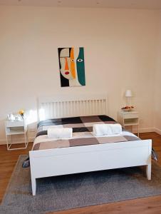 1 dormitorio con 1 cama y una pintura en la pared en B&b Nicole, en Valguarnera Caropepe