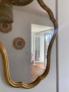 un miroir avec un cadre en or sur un mur dans l'établissement Rez de villa avec jardinet proche de la plage, à Hyères