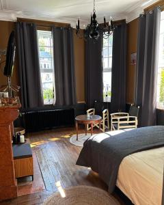a bedroom with a bed and a table and windows at Monsieur Michel in Dinant