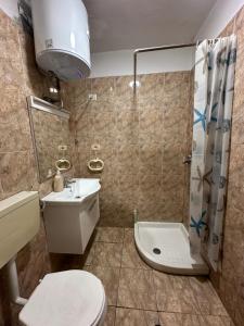 a bathroom with a toilet and a sink and a shower at Urban Life Tirana- Economy Rooms in Tirana