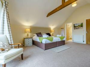 a bedroom with a bed and a chair in it at 2 Bed in Thirsk 48116 in Carthorpe