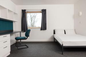 Schlafzimmer mit einem Bett, einem Schreibtisch und einem Stuhl in der Unterkunft Wenlock Court in Luton