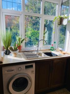 a kitchen with a sink and a washing machine at Large Home with 5 car Parking next to Train station, Airport, NEC in Marston Green