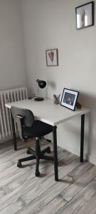 a desk with a chair and a lamp on it at F2, entièrement neuf, 65m² in Montceau-les-Mines