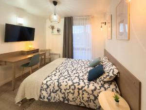a bedroom with a bed and a desk and a deskablish at Le Cosy Saint-Cyr in Saint-Cyr-lʼÉcole +32 photos