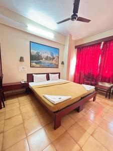 una camera con un grande letto e un ventilatore a soffitto di Hotel Prabha a Ratnagiri