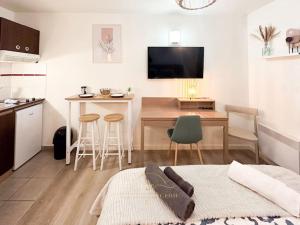 a room with a kitchen with a table and a kitchen at Le Cosy Saint-Cyr in Saint-Cyr-lʼÉcole