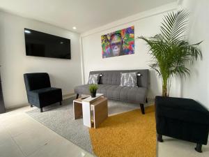 sala de estar con sofá y silla en comoda casa para descansar, en Manizales
