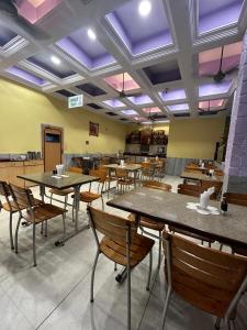un ristorante con tavoli e sedie in una stanza di Hotel Prabha a Ratnagiri