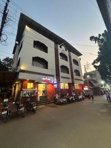 un edificio con moto parcheggiate di fronte di Hotel Prabha a Ratnagiri