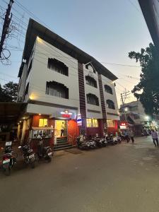 a building with motorcycles parked in front of it at Hotel Prabha in Ratnagiri