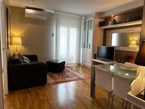 ein Wohnzimmer mit einem schwarzen Sofa und einem Tisch in der Unterkunft Petit Rosselló in Barcelona