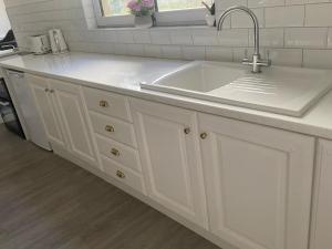 a white kitchen with a sink and a counter at Johnsville House in Carlow