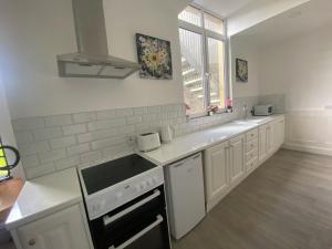 a kitchen with white counters and a sink and a window at Johnsville House in Carlow