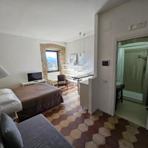 a hotel room with two beds and a desk at ESSENTIAL ROOM & PARKING in Centro Città con Parcheggio Privato e WIFI in Potenza