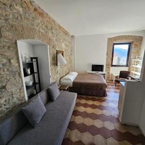 a bedroom with a couch and a bed in a room at ESSENTIAL ROOM & PARKING in Centro Città con Parcheggio Privato e WIFI in Potenza