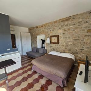 1 dormitorio con 1 cama grande y pared de piedra en ESSENTIAL ROOM & PARKING in Centro Città con Parcheggio Privato e WIFI, en Potenza
